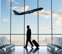 Businessman walking in airport with luggage for Harlee Reed Voice